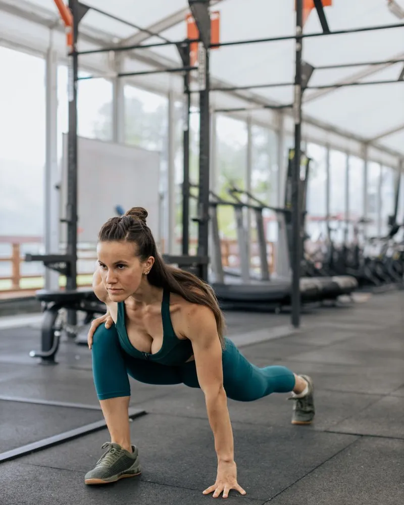 Mulher alongando o quadril na academia antes do treino